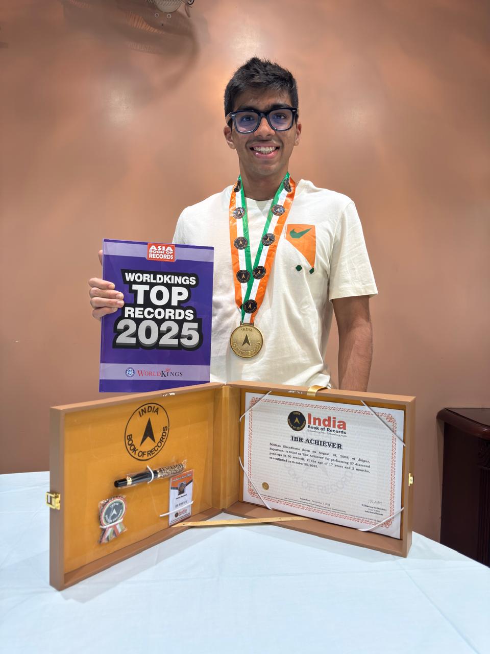 Soumya displaying medals, a trophy, and certificates